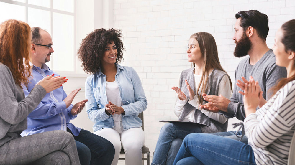 a-group-of-individuals-clapping-in-a-cbt-session